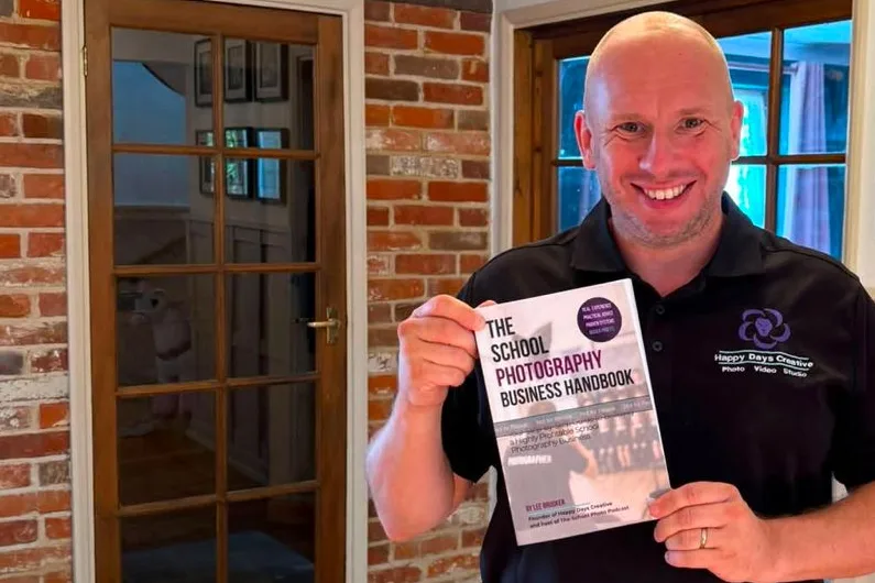 Lee Brooker holding a copy of The School Photography Business Handbook.